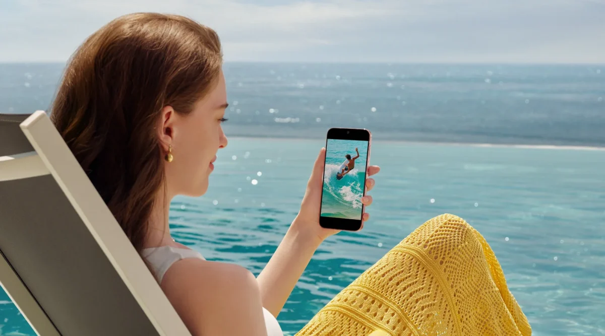 Девушка с Huawei Pura 90s Pro в руке на фоне воды