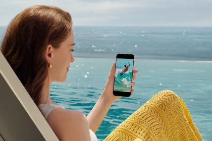 Девушка с Huawei Pura 90s Pro в руке на фоне воды