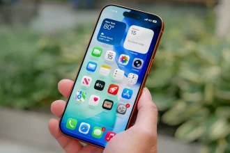 iPhone в руке с домашним экраном iOS