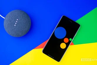 Логотип Google Ассистента на экране смартфона рядом с колонкой Nest Mini
