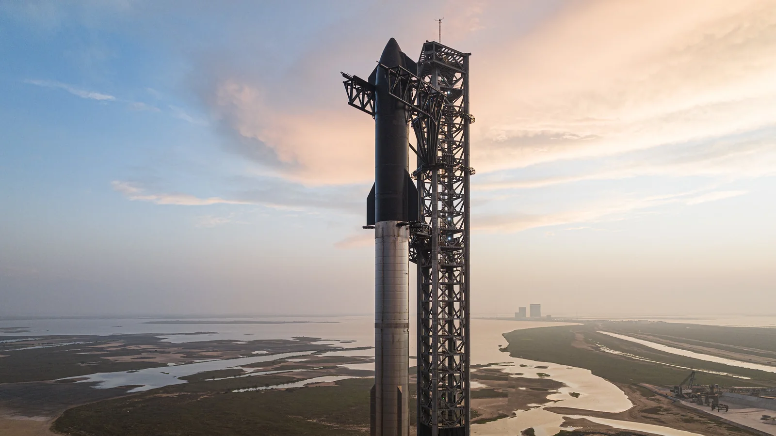 Starship на стартовом столе в Старбейсе рядом с башней обслуживания