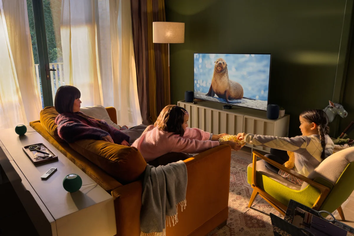 Гостиная с телевизором, Apple TV 4K и колонками HomePod mini спереди и сзади дивана