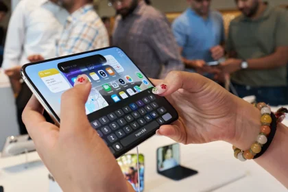 Покупательница держит раскрытый iPhone Duo с клавиатурой на внутреннем экране в Apple Store