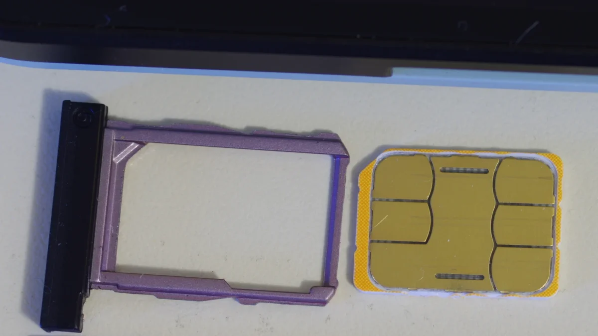 Nano-SIM-карта рядом с лотком для SIM, вынутым из смартфона